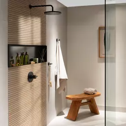 Douche ouverte avec paroi en verre, carrelage imitation bois et niche murale noire le long du mur arri&egrave;re